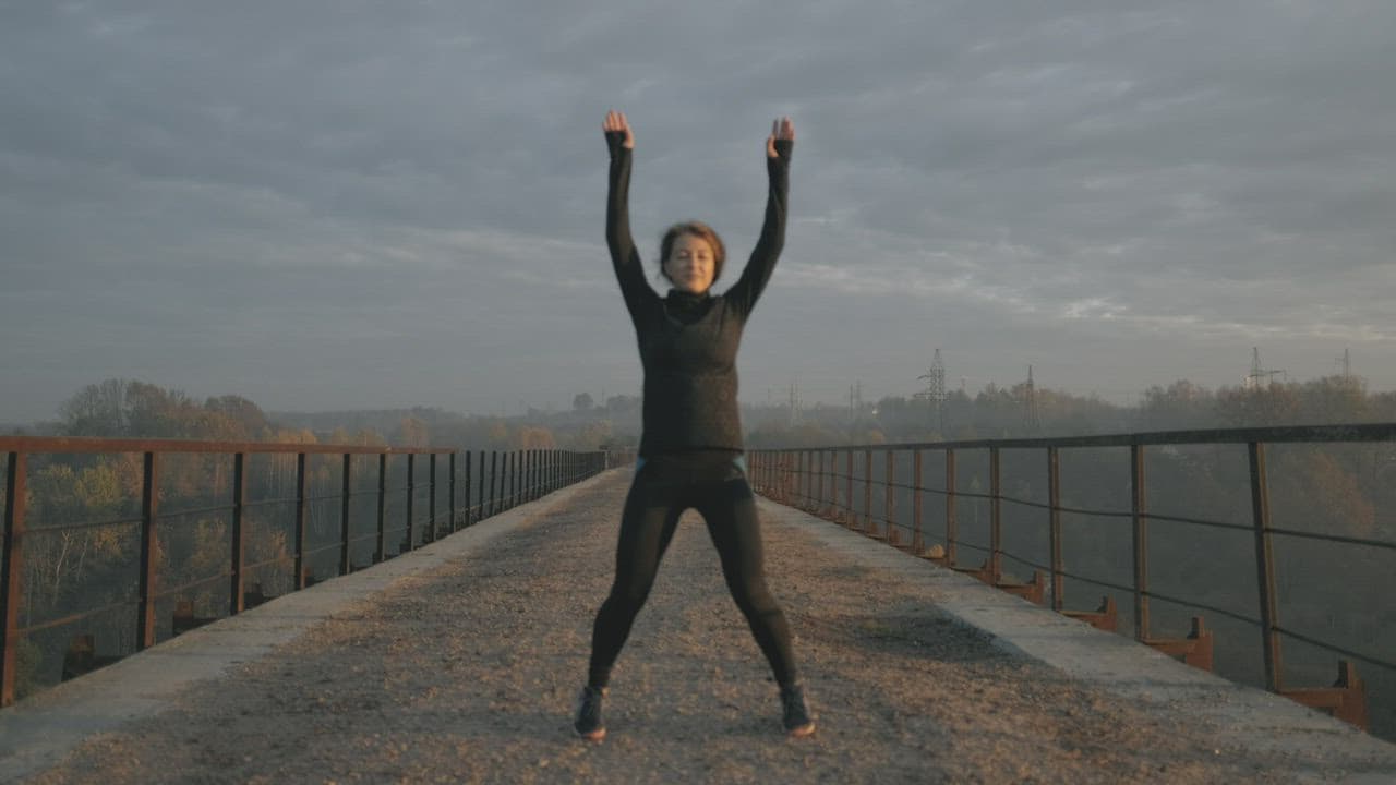 Woman doing jumping jacks outdoors